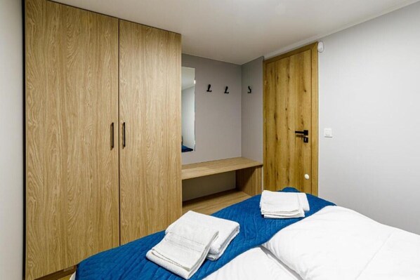 Une chambre à coucher avec un lit, une armoire en bois et un miroir au mur.