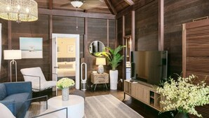 Un salon moderne avec un canapé, une table basse, un téléviseur et des plantes décoratives.