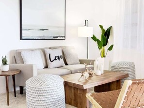 A modern living room with a sofa, a coffee table, and a side table.