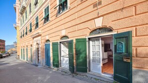 Een rij traditionele gebouwen in Europese stijl, met groene luiken en een helderblauwe lucht.