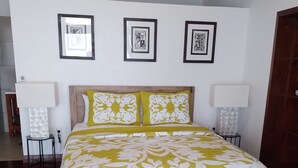 Un dormitorio con una cama grande, dos mesitas de noche y tres cuadros en la pared.