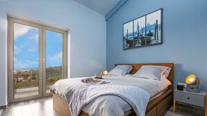 A bedroom with a large bed, a nightstand, a lamp, and a painting of a canal scene. - Villa Soleil in peaceful location with a sea view (Mali Kosi)
