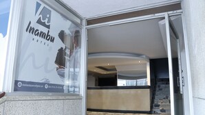 The entrance of Inambu Hotel with a reception desk and a staircase leading to the upper floor. - Hotel Inambu (Villavicencio)