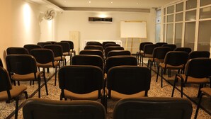 A conference room with rows of chairs, a whiteboard, and a fan. - Hotel Inambu (Villavicencio)