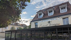 A building with a sign reading "Le point d'origine." It features large windows and a tiled roof. - Le Logis d'Origine. (Marly-le-Roi)