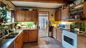 A kitchen with wooden cabinets, a stove, a microwave, and a sink.
