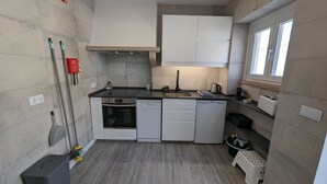 A compact kitchen with a stove, dishwasher, and sink.