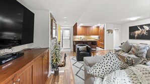 A modern living room with a flat-screen TV, a Christmas tree, and a cozy seating area. - Wi1073-2 (Keystone)