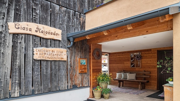 A wooden building with a sign reading 'Casa Majonade' and another sign indicating 'Cartieres da Fitar Apartments.' - Apartment 'Ciasa Majonade Pozza Di Fassa Tipo1' with Mountain View, Private Terrace and Wi-Fi (Pozza di Fassa)