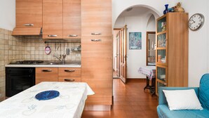 Una cocina con armarios de madera, una estufa y una mesa de comedor con un plato azul.