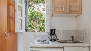Une cuisine équipée d’une machine à café, d’un évier et de meubles de rangement en bois.