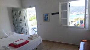 Une chambre à coucher avec un lit, une porte, une fenêtre et une vue sur l’extérieur.