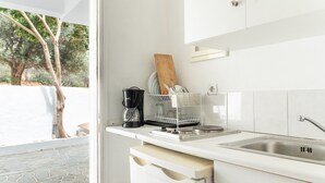 Eine moderne Küche mit integriertem Spülbecken, einer Kaffeemaschine und einem Geschirrgestell.