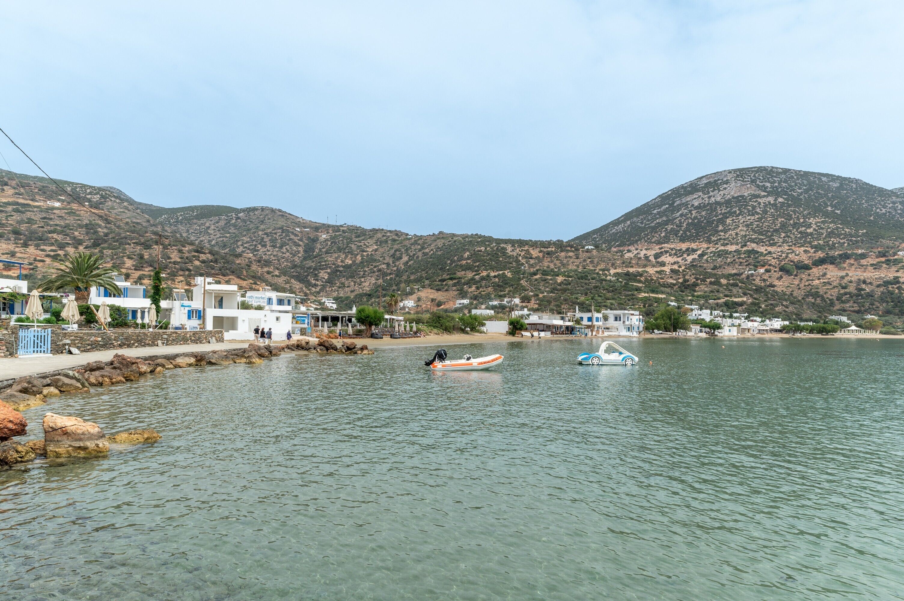 Une ville côtière avec des bâtiments qui bordent le front de mer, une vue dégagée sur la mer et des montagnes en arrière-plan.