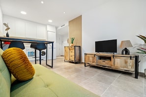 Een moderne woonkamer met een bank, een televisie en een houten kast.