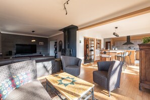 A modern living room with a sofa, armchairs, a coffee table, and a TV. - Maison Paul – Villa on the Hill in the Pyrenees Mountain View, Private Terrace, High-Speed Wi-Fi (Bagnères-de-Bigorre)