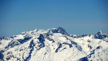 Een met sneeuw bedekte bergketen met ruige toppen en een helderblauwe lucht.