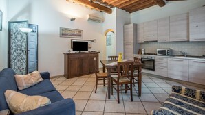 Un espace de vie compact comprenant un coin repas, une cuisine et un coin salon.