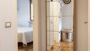 A room with a bed, a mirror, a wall-mounted light, and a small basket. - N269 - Numana, single four-room villa with garden (Numana)