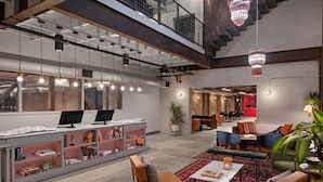 Una hall moderna con reception, area salotto e una scala.