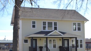 A two-story house with a front porch, a garage, and a fenced yard.