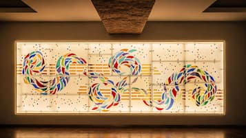 Un intérieur moderne agrémenté d’une grande installation artistique abstraite sur un mur.