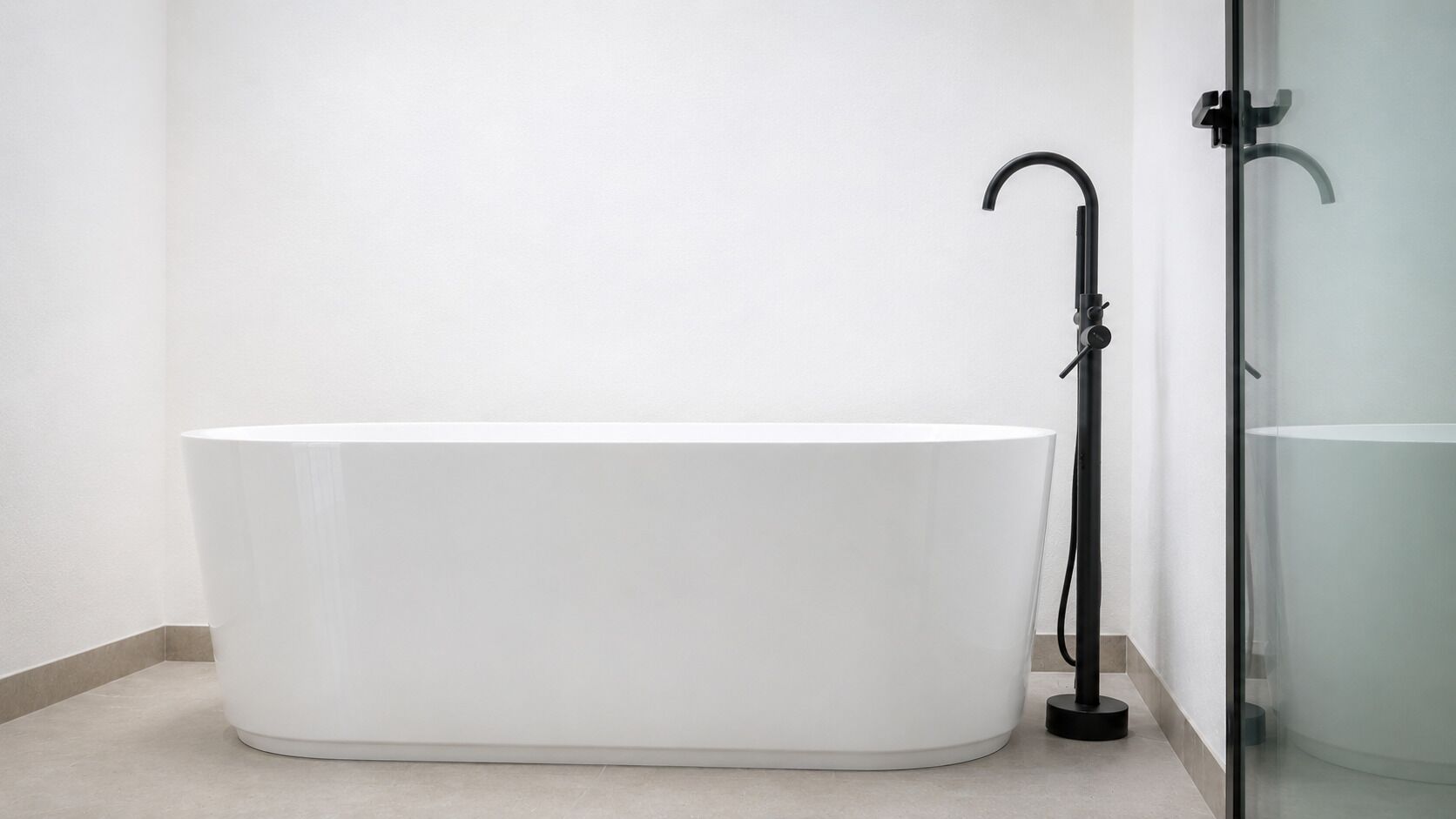 A modern bathroom with a freestanding bathtub, a glass shower enclosure, and a minimalist design.