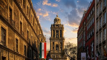 A historic building with a bell tower, large windows, and a flag.