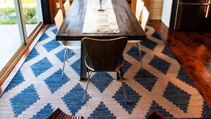 Un coin repas en bois avec une table, des chaises et un tapis.