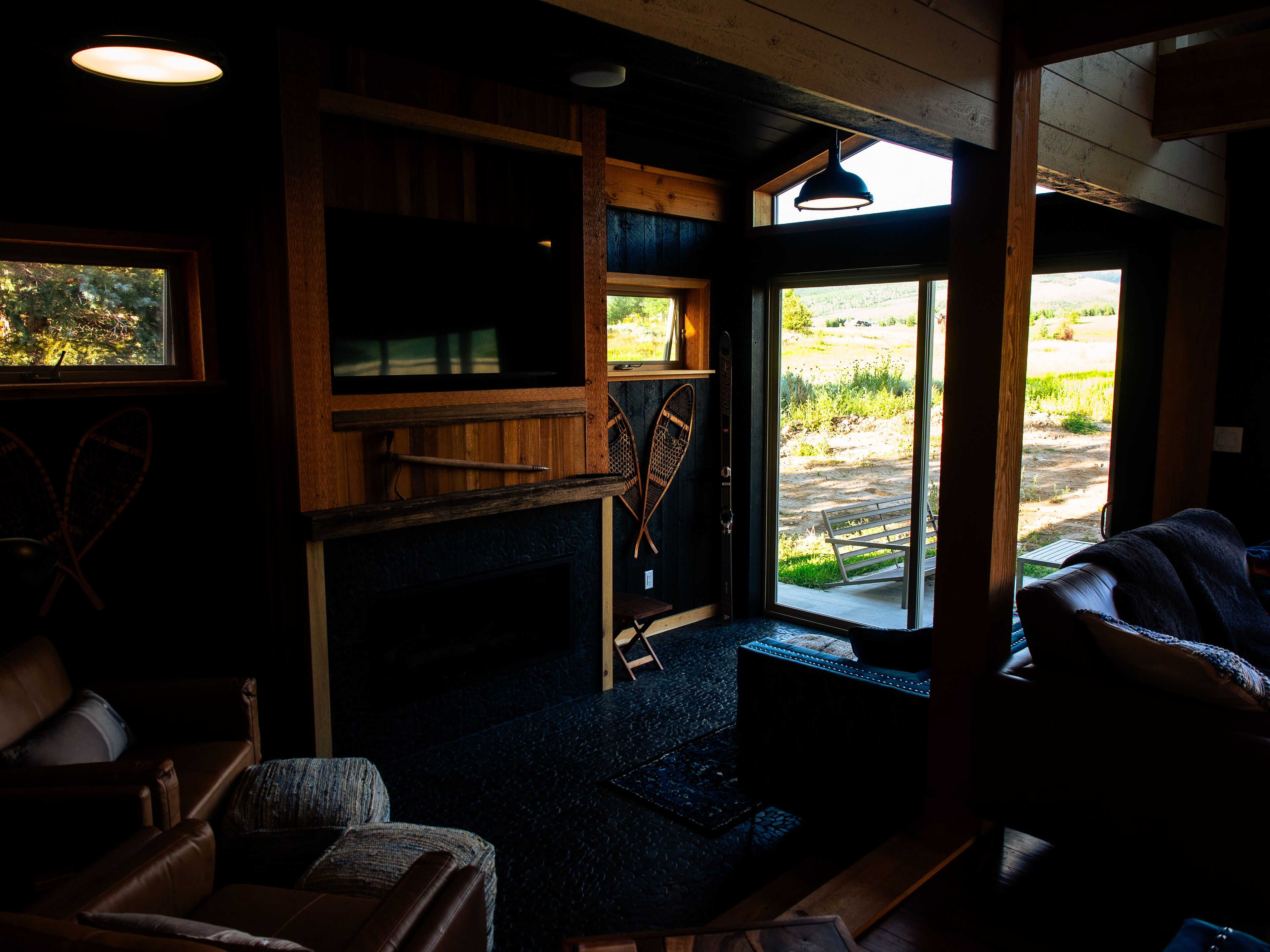 Ein gemütliches Zimmer mit Kamin, Holzmöbeln und Blick ins Freie.