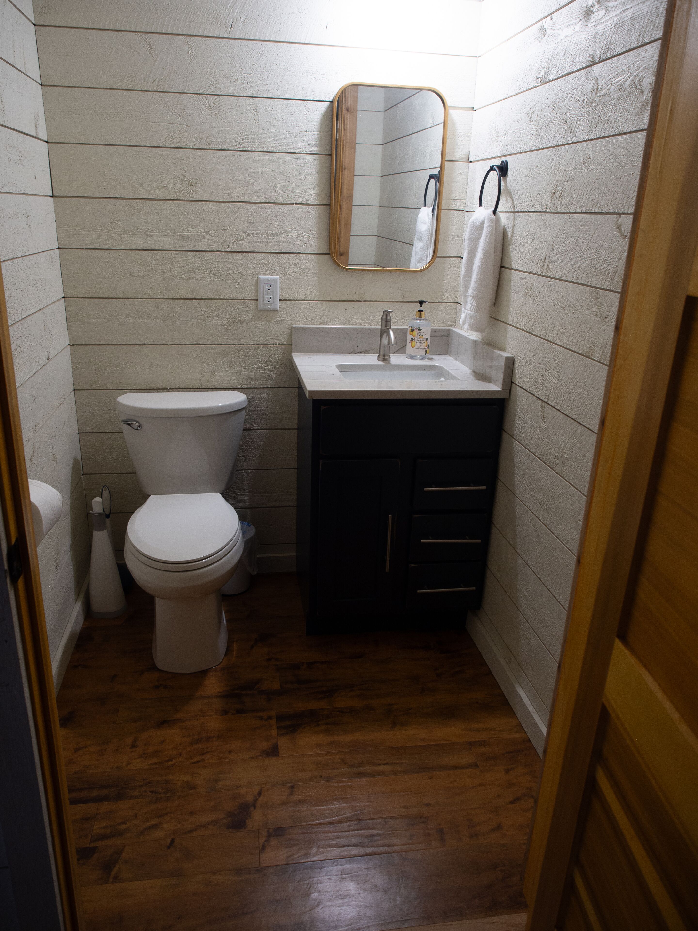 A small bathroom with a toilet, sink, and mirror.