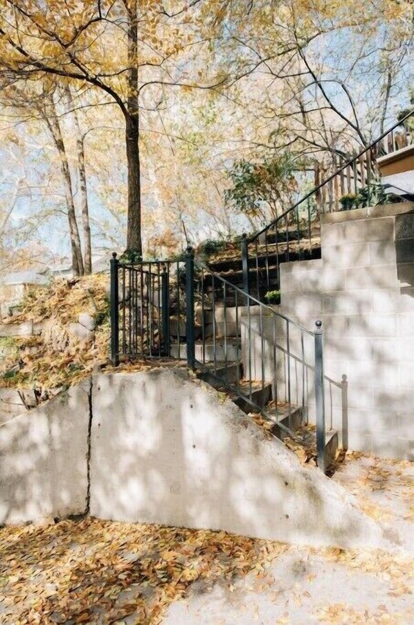 Una escalera de concreto con barandilla de metal que lleva a un edificio.