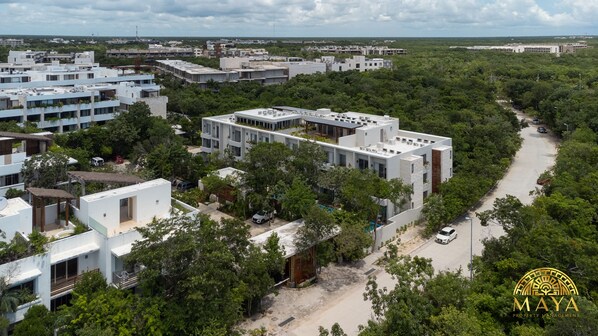 Una zona residencial moderna con varios edificios, una calle despejada y zonas verdes circundantes.