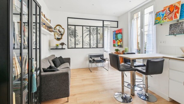 A modern kitchen with a dining area, a sofa, and a coffee table. - Appart T2 Cosy et Chaleureux au coeur du 11eme (Paris)