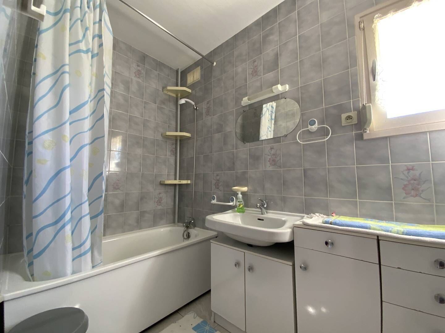 Un baño con bañera, lavabo y espejo.
