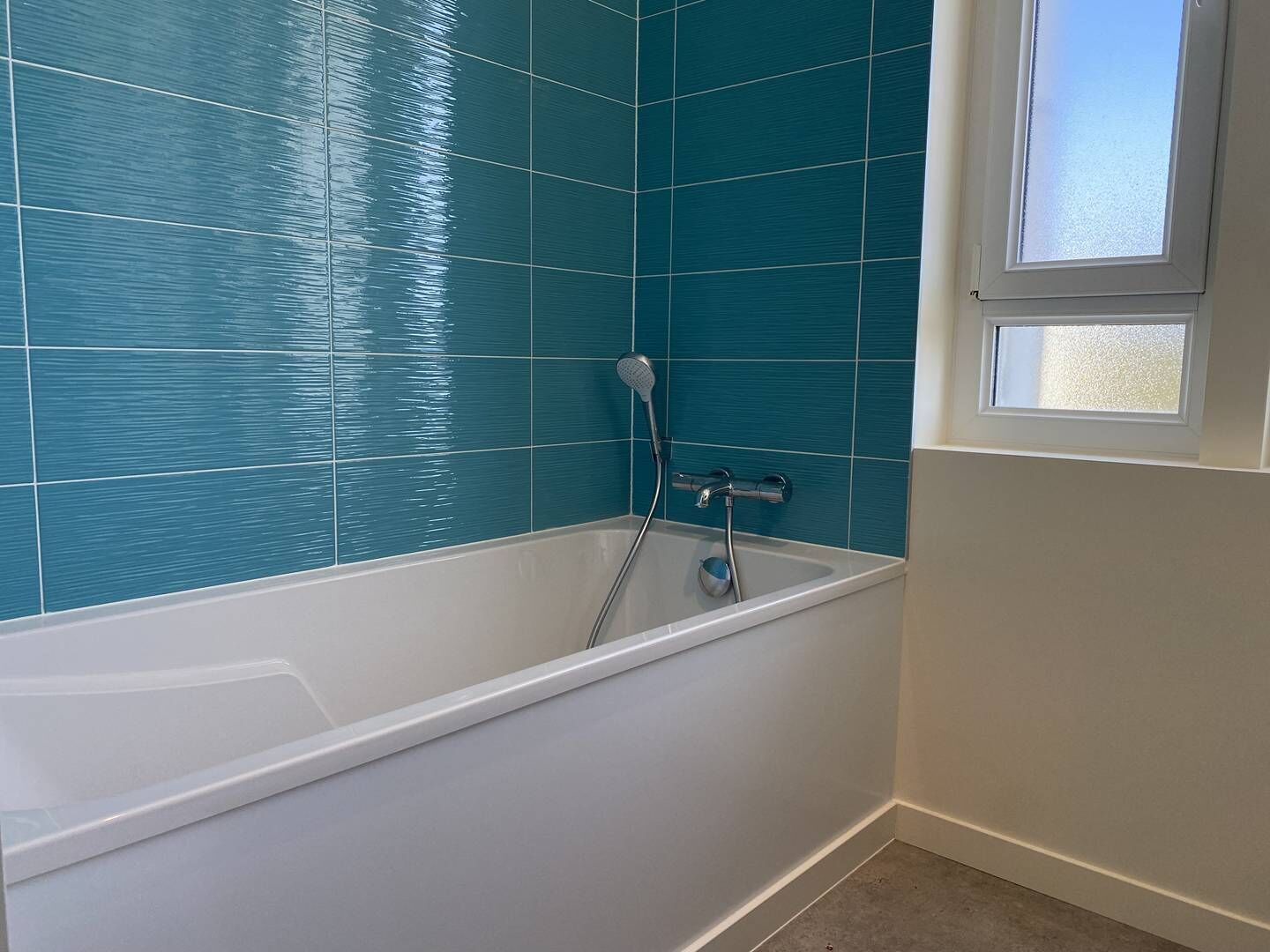A bathroom with a bathtub, a shower, and a window.
