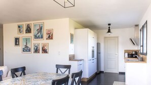 Una cocina moderna con armarios blancos, un refrigerador y una cafetera sobre la encimera.