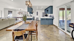 A spacious kitchen with a dining area, a sofa, and a view of the outdoors.