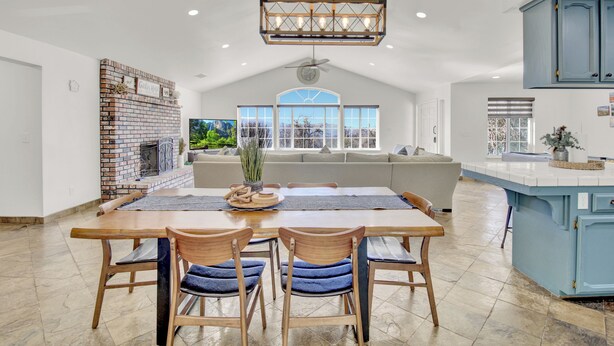 A spacious kitchen with a large island, a brick fireplace, and a view of the outdoors.