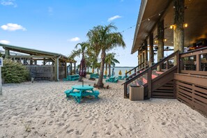 Un restaurant situé en bord de mer, avec une terrasse, une plateforme en bois et une vue sur l’océan.