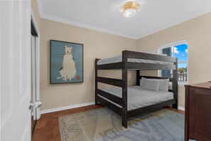 A bunk bed room with a window, a rug, and a wall with a framed picture. - South Harbour 2D | Sunset Views | Pensacola Beach | My Beach Getaways (Pensacola Beach)