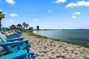 Une plage avec des chaises longues bleues et une mer calme.