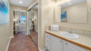 Une salle de bain avec un grand miroir, un lavabo et une douche.