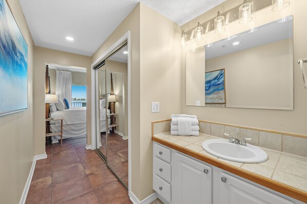 A bathroom with a large mirror, a sink, and a shower. - South Harbour 2D | Sunset Views | Pensacola Beach | My Beach Getaways (Pensacola Beach)