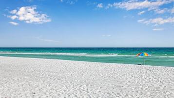 Una playa de arena blanca y cielo azul cristalino.