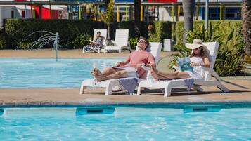 A pool area with lounge chairs and a water fountain.