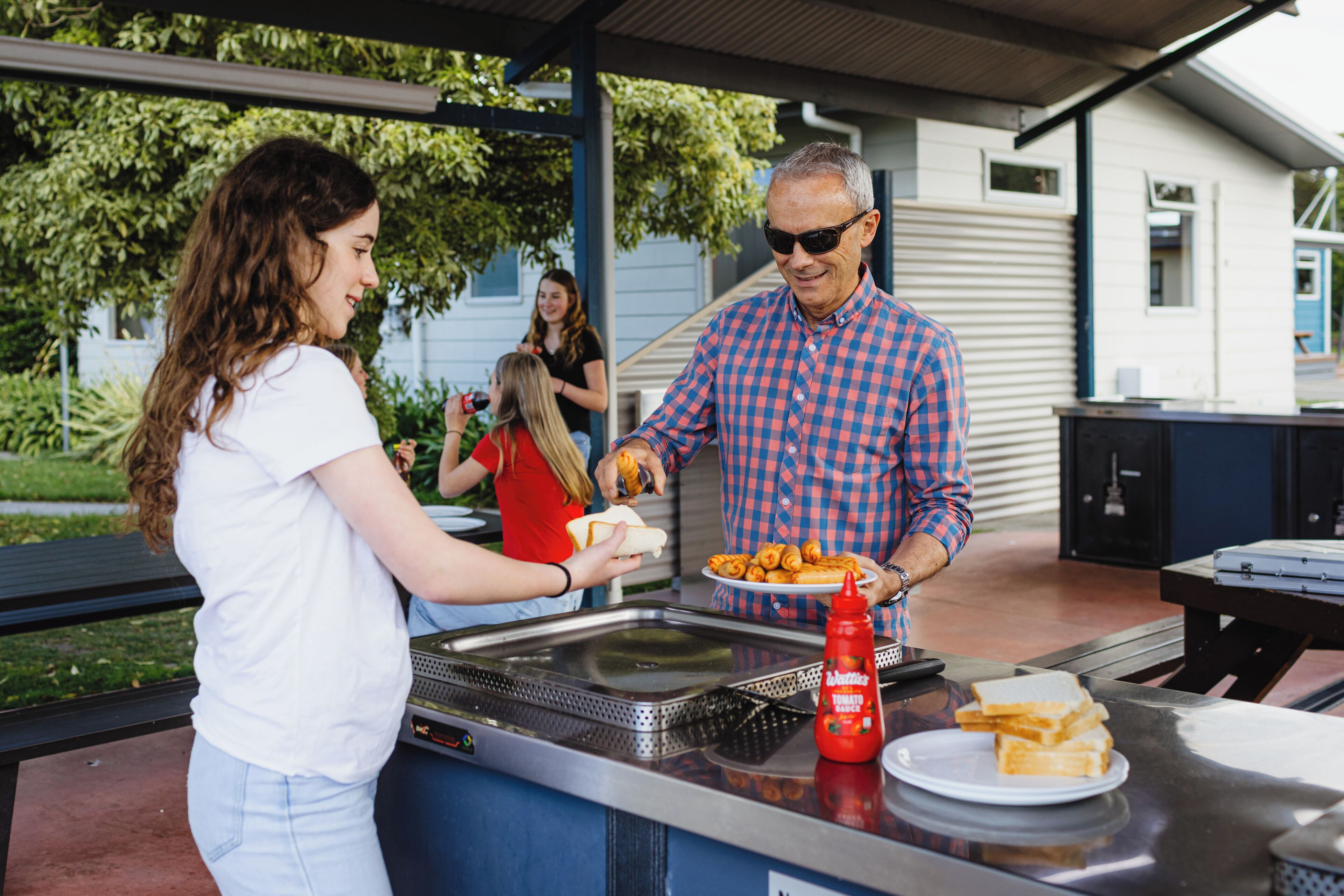 A barbecue grill with food and condiments.
