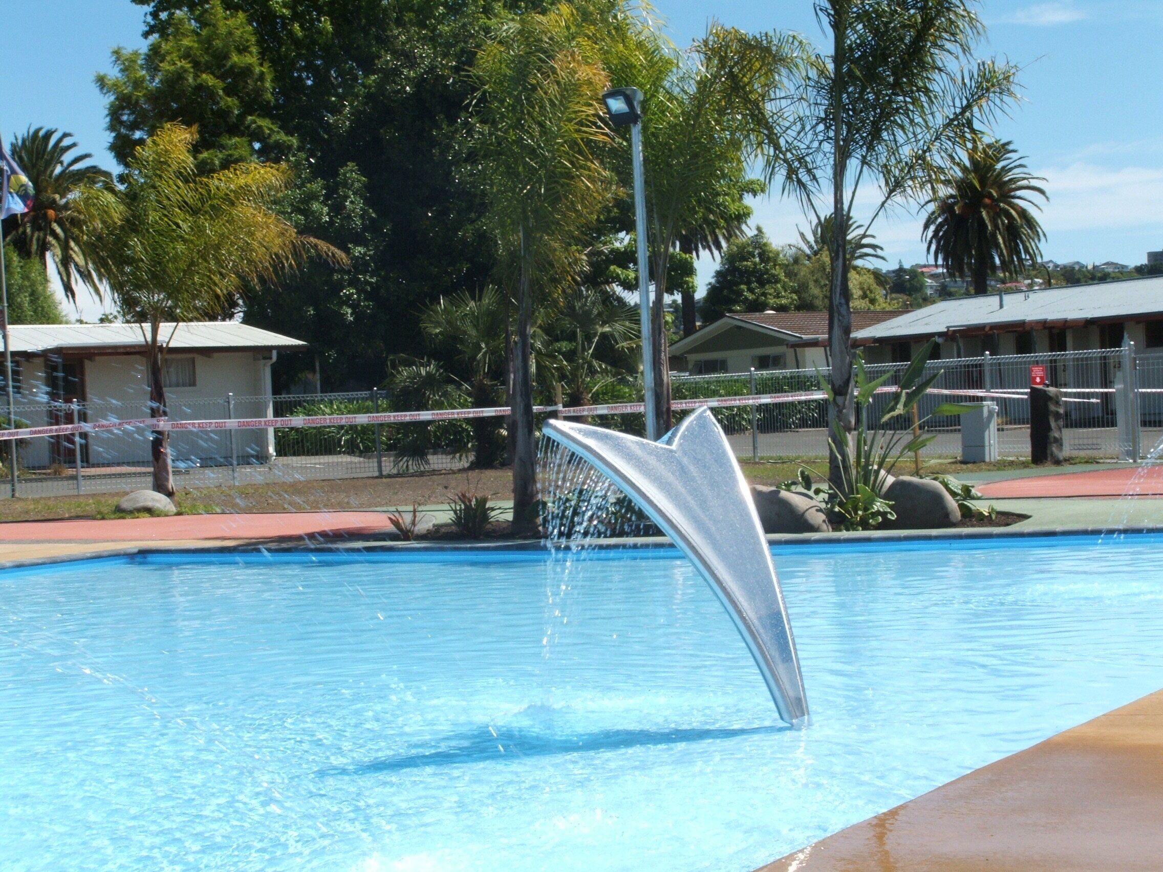 En swimmingpool med en vandfigur formet som en delfin.