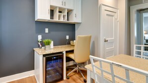 A compact kitchen with a built-in dishwasher, a white cabinet above the counter, and a chair at the dining table. - Stunning Charlotte Retreat ~ 2 Mi to City Center! (Charlotte)