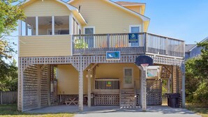 A two-story house with a balcony, a basketball hoop, and a sign indicating a vacation rental. - 4 br, loft, dog friendly, pool firepit! (Avon)